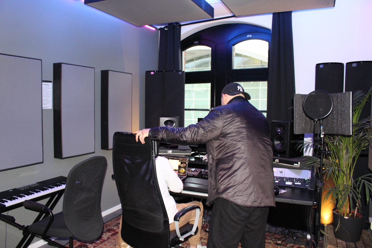 Two men working together in a brightly lit recording studio.